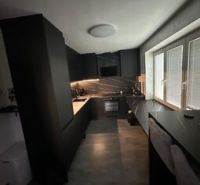 A modern kitchen in a 2-room apartment with an elegant design and large windows.