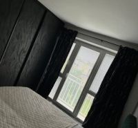 Bedroom in a 2-room apartment with a bed and a window, verified real estate agency.