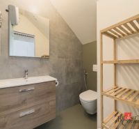 Bathroom in a 3-room apartment with a sink, wooden shelf, and a mirror on the wall.