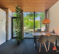 Dining area in a 3-room apartment with large windows and a garden.