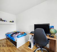 A children's room in a family house with a bed, a table, and a wooden decor floor.