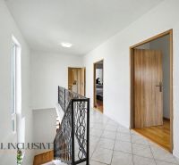Hallway in a family house with a tiled floor and a staircase.