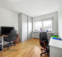 A home office with a computer and wood-patterned flooring in a family house.