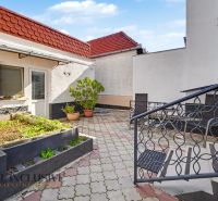 The courtyard of a family house in Trstice with a terrace and flower beds in pots.
