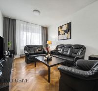 Living room in a family house with black leather furniture and a television.
