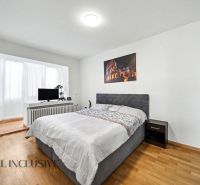 A bedroom with a wood-patterned floor and a painting in a family house.