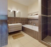 A bathroom in a 4-room apartment with a bathtub, shower, and storage space.