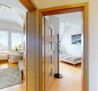 Interior of a 4-room apartment with wood-decor flooring, an armchair, and bright rooms.