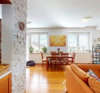 Living room with a sofa set, dining table, and wood-patterned flooring.