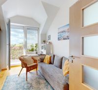 A room with a sofa and an armchair, large window, wooden decor flooring, 4-room apartment.