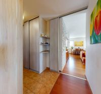 In the 4-room apartment, there are wardrobes, paintings, and a floor with a wooden decor.