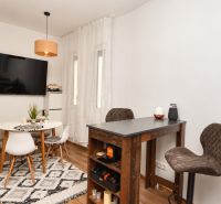 Interior of a 1-room apartment with a wooden decor floor and a dining table.