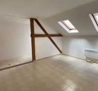 Attic office with ceramic floor and skylights, wooden beam.