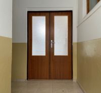 In the offices, there are double doors with glazing and light brown walls.