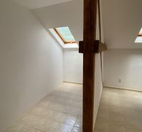 Attic office space with a wooden beam and skylights.
