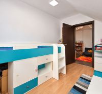 A children's room in a family house with colorful furniture and a wooden decor floor.
