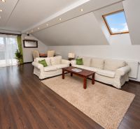 Attic living space with wood-decor flooring in a family house.