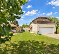 A family house in Mosonmagyaróvár with a large garden and garage, surrounded by greenery.