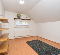 A room in a family house with a floor featuring a wooden decor, a shelf, and a window.