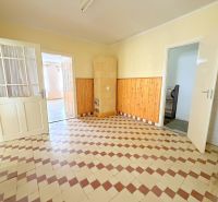 A room in a family house with tiled flooring and wooden wall paneling.