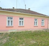 A family house in Dunakiliti with a pink facade and four windows on the ground floor.