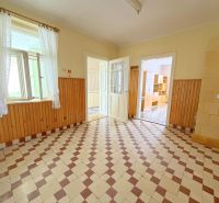 Interior of a family house, a bright room with a tiled floor and wooden wall paneling.