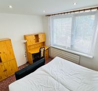 A bedroom in a 3-room apartment with wooden furniture and a large window.