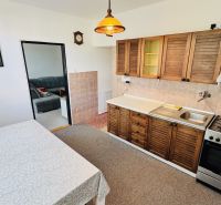 A kitchen in a 3-room apartment with a gas stove and a kitchen unit with a wooden decor.