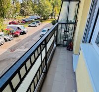 A balcony with a view of trees and cars on Nádražná Street in Partizánske, the space of a 3-room apartment.