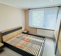 Bedroom with a bed, nightstands, and a large wardrobe in a 3-room apartment.