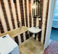 A bathroom with retro tiles and a bathtub, a washing machine in a 3-room apartment.