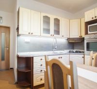 A kitchen in a 2-room apartment with built-in appliances and a dining table.