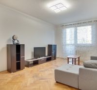 Living room in a two-room apartment with a wooden decor floor and a light interior.