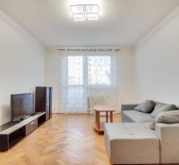 Living room with a sofa and TV in a two-room apartment, floor with wood decor.