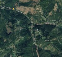 Aerial view of Oščadnica with surrounding forested areas, roads, and buildings.