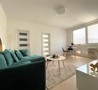 Bright living room in a 3-room apartment with a sofa, table, and dining area.