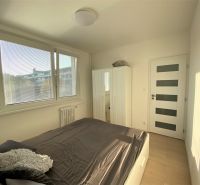 Bedroom in a 3-room apartment with a bed, wardrobe, window, and modern doors.