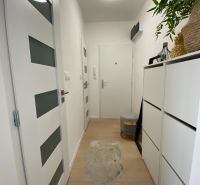 The entrance hall of a 3-room apartment with white furniture and wooden flooring.