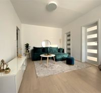 Living room with a sofa and decorations in a 3-room apartment, bright interior.