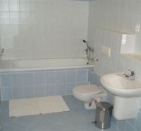 Bathroom in a 3-room apartment with a bathtub, sink, and toilet, blue and white tiles.