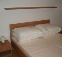 Bedroom in a 3-room apartment with a bed and a nightstand with a lamp.
