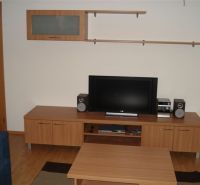 Living room in a 3-room apartment with a wooden decor floor, television, and furniture.