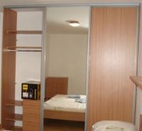 A bedroom with a wood-patterned floor and a built-in wardrobe in a 3-room apartment.