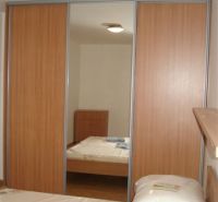 A bedroom in a 3-room apartment with a large built-in wardrobe and a floor with a wooden decor.