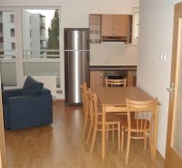 Kitchen connected with dining room, wooden floor decor, seating in a 3-room apartment.