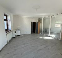 Office spaces with wood-patterned flooring, glass partitions, and white walls.