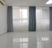 Spacious commercial spaces with large windows and white tiles on the floor.