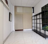 Small room with a shelf, white paneling, and green nature-themed wallpaper.