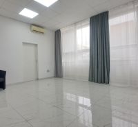 Stylish commercial spaces with white walls, ceramic flooring, an armchair, and a table.