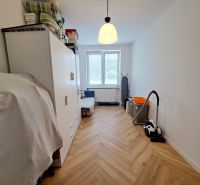 A bright room in a 3-room apartment with a wooden decor floor and storage space.